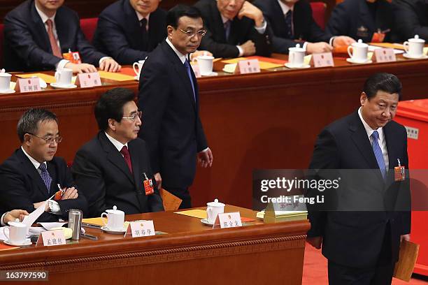 Chinese President Xi Jinping and Premier Li Keqiang walk on the way to cast their votes into a box as Guangdong Communist Party Secretary Hu Chunhua...