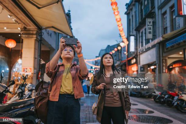 asian chinese female tourist photographing old town with smart phone in taipei city - city country stock pictures, royalty-free photos & images
