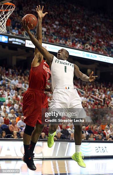 Durand Scott of the Miami Hurricanes goes up for a shot against Richard Howell of the North Carolina State Wolfpack in the first half during the...