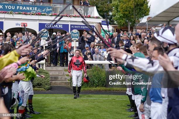 Jockey Paul Hanagan walks through a guard of honour before riding in his last ever race before retirement at York Racecourse on August 25, 2023 in...