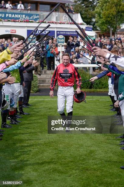 Jockey Paul Hanagan walks through a guard of honour before riding in his last ever race before retirement at York Racecourse on August 25, 2023 in...