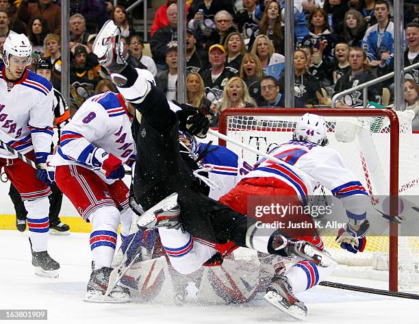 Chris Kunitz of the Pittsburgh Penguins is up ended by Steve Eminger of the New York Rangers during the game at Consol Energy Center on March 16,...