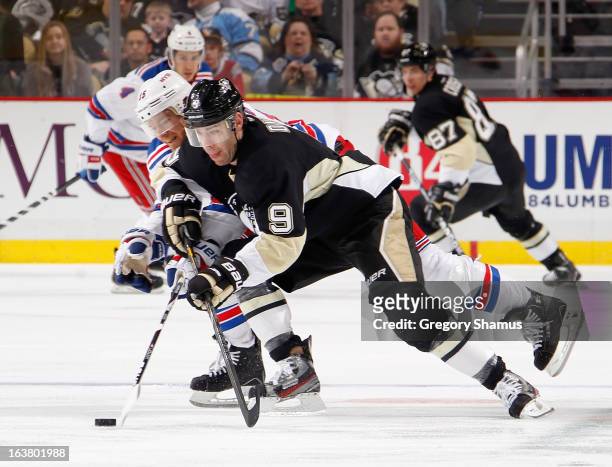 Pascal Dupuis of the Pittsburgh Penguins skates past he defense of Jeff Halpern of the New York Rangers on March 16, 2013 at Consol Energy Center in...