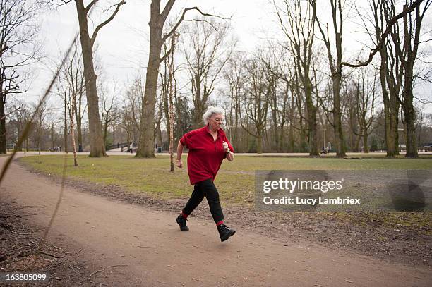 elderly lady jogging in the park - senior woman running stock pictures, royalty-free photos & images