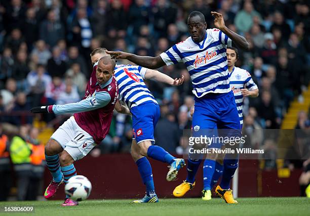 Gabriel Agbonlahor of Aston Villa is challenged by Chris Samba of Queens Park Rangers during the Barclays Premier League match between Aston Villa...