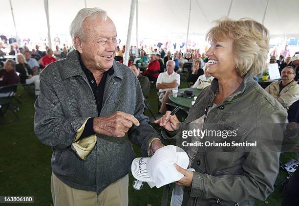 Arnold Palmer signs hats for volunteer Mona MacDonald during a volunteer appreciatiion breakfast at the Bay Hill Club & Lodge in Orlando, Florida,...