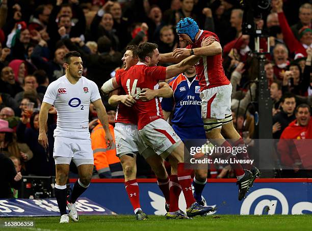 Alex Cuthbert of Wales celebrates with teammates Dan Biggar and Justin Tipuric after scoring his team's second try during the RBS Six Nations match...