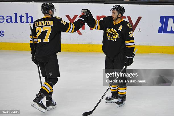 Dougie Hamilton and Patrice Bergeron of the Boston Bruins high five after the win against the Washington Capitals at the TD Garden on March 16, 2013...