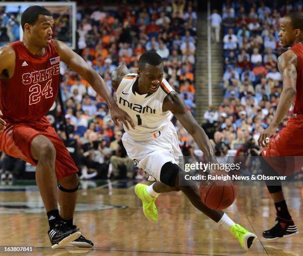 Miami guard Durand Scott races past North Carolina State forward T.J. Warren and guard Lorenzo Brown in the second half of a semifinal in the ACC...