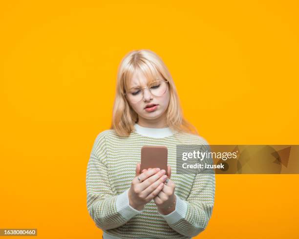 portrait of worried teenage girl using smart phone - adolescent portable stock pictures, royalty-free photos & images
