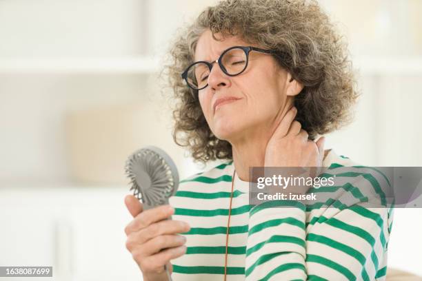 menopausal woman having a hot flash - hand fan stock pictures, royalty-free photos & images