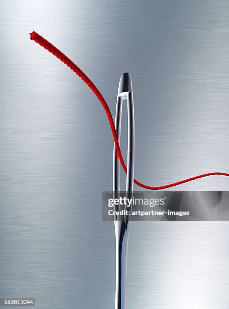 sewing needle with a red thread through the eye - 準確 個照片及圖片檔