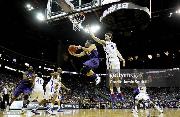 Angel Rodriguez of the Kansas State Wildcats shoots against Jeff Withey of the Kansas Jayhawks in the first half during the Final of the Big 12...