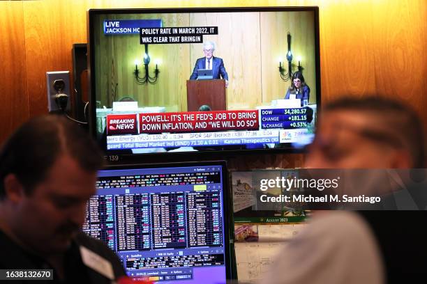 Federal Reserve Chairman Jerome Powell’s speech is seen on a television screen as traders work on the New York Stock Exchange floor during morning...