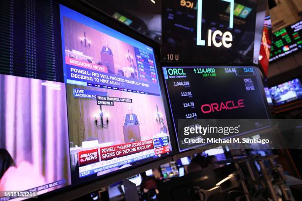 Federal Reserve Chairman Jerome Powell’s speech is seen on a television screen as traders work on the New York Stock Exchange floor during morning...