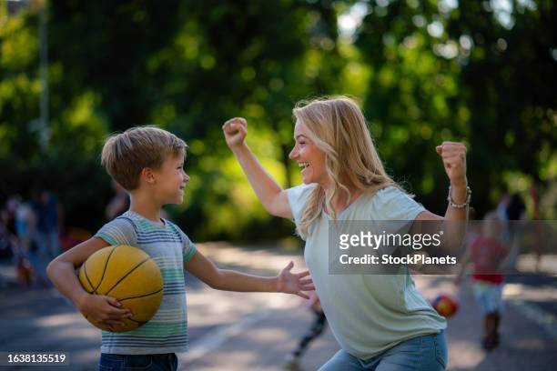 mother supporting her little basketball player - mom cheering stock pictures, royalty-free photos & images
