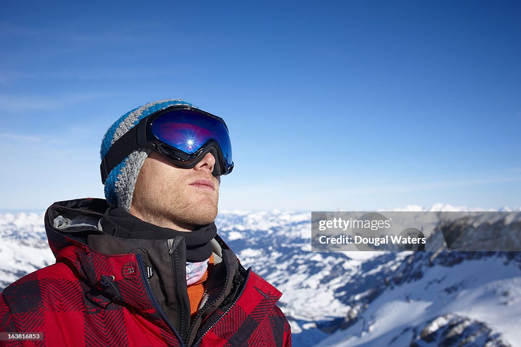 A man stands in snowy mountain landscape.