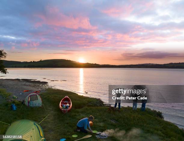 canoeing family camping by lake at sunset - canoeing uk stock pictures, royalty-free photos & images