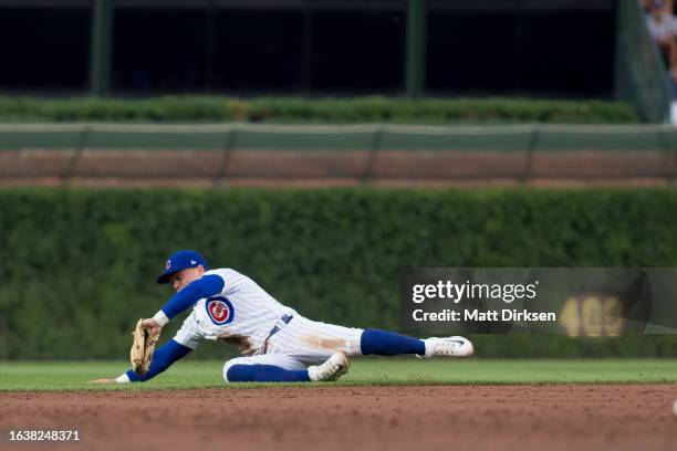 Nico Hoerner of the Chicago Cubs makes a diving stop in a game against the Washington Nationals at Wrigley Field on July 19, 2023 in Chicago,...