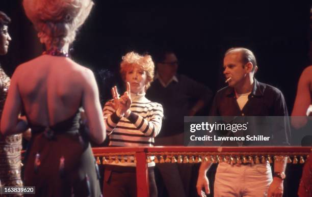 American actress Gwen Verdon helps her husband, director, dancer, and choreographer Bob Fosse , direct a scene in the film 'Sweet Charity' at...