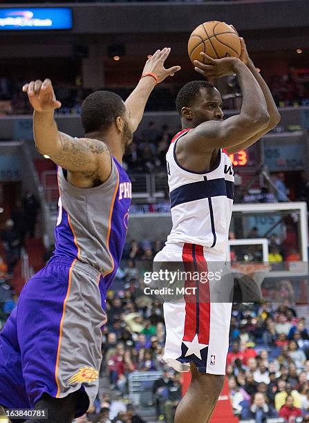 Washington Wizards small forward Martell Webster hits a three-point shot in front of Phoenix Suns power forward Marcus Morris during the second half...