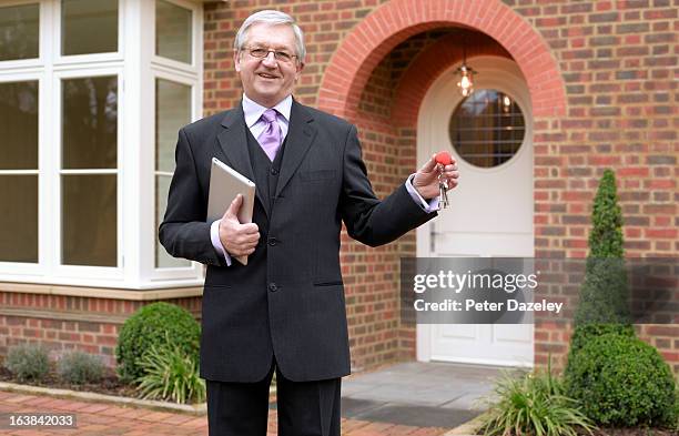 estate agent with keys to new house - sold palabra en inglés fotografías e imágenes de stock