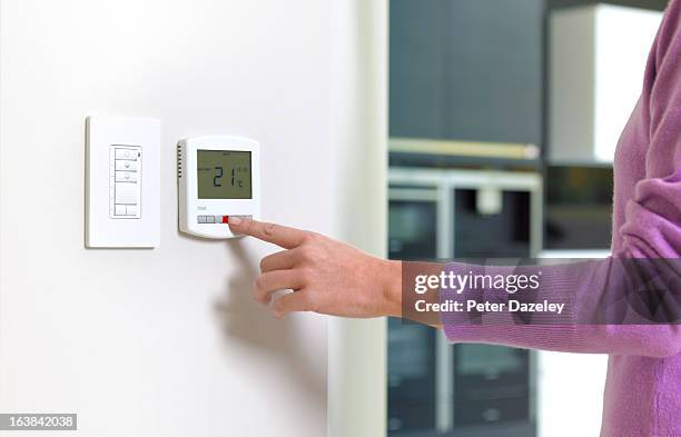 young woman changing heating - temperature imagens e fotografias de stock