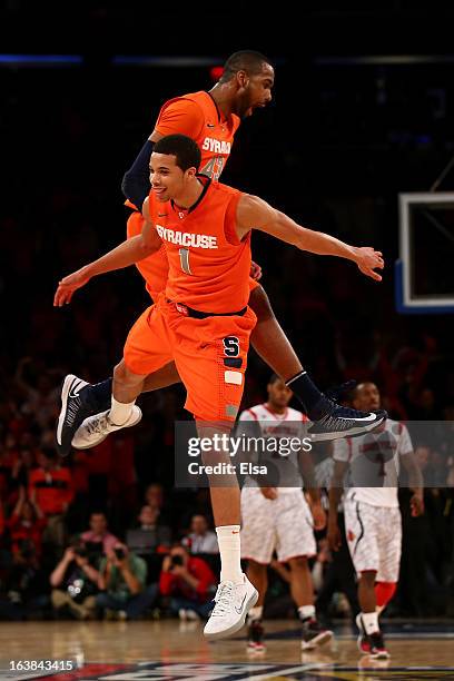 James Southerland and Michael Carter-Williams of the Syracuse Orange celebrate a play in the second half against the Louisville Cardinals during the...
