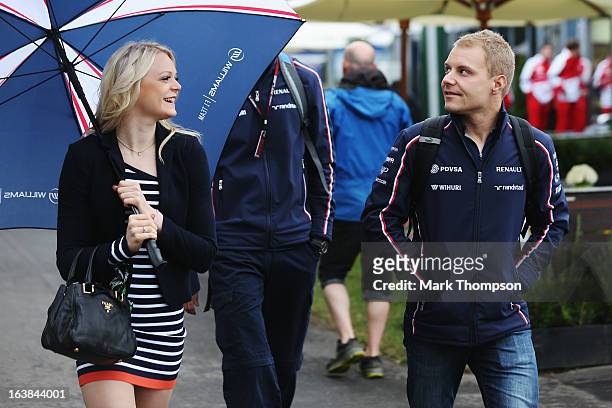 Valtteri Bottas of Finland and Williams and his girlfriend Emilia Pikkarainen arrive in the paddock before the weather delayed qualifying session for...