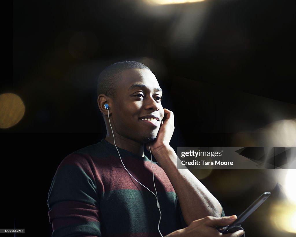 Man smiling with headphones and mobile phone