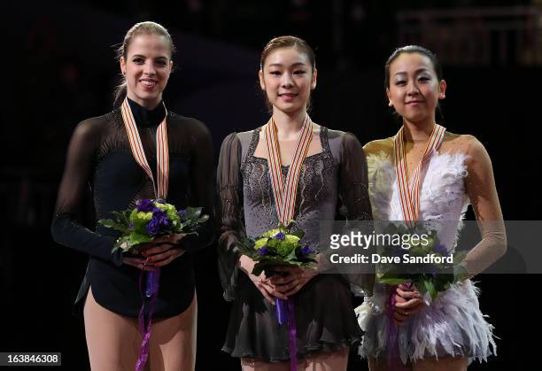 Yuna Kim of South Korea celebrates winning the gold medal with Carolina Kostner of Italy winning silver medal and Mao Asada of Japan winning the...