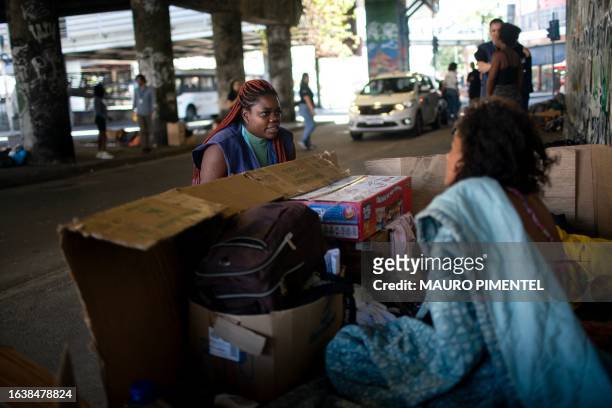 Social Worker Silvana Amaral talks with a homeless woman during a visit of Consultorio de Rua health team to a homeless encampment under the...