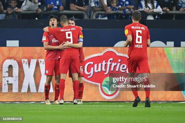 Shuto Machino of Holstein Kiel celebrates with teammates after scoring the team's second goal during the Second Bundesliga match between FC Schalke...