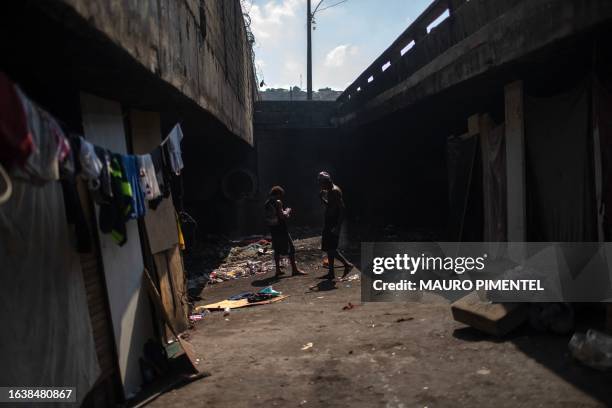 Homeless men stand inside a homeless encampment in the suburbs of Rio de Janeiro, Brazil on July 31, 2023. Thirteen teams from the municipal program...