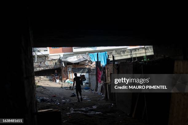 Homeless man walks out from a homeless encampment located under a viaduct in the suburbs of Rio de Janeiro, Brazil on July 12, 2023. Thirteen teams...