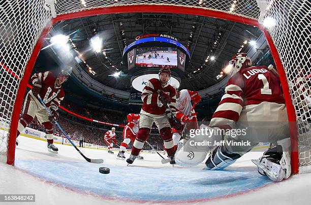 Alexandre Burrows, Dan Hamhuis and Roberto Luongo of the Vancouver Canucks watch a shot by Henrik Zetterberg of the Detroit Red Wings enter the net...