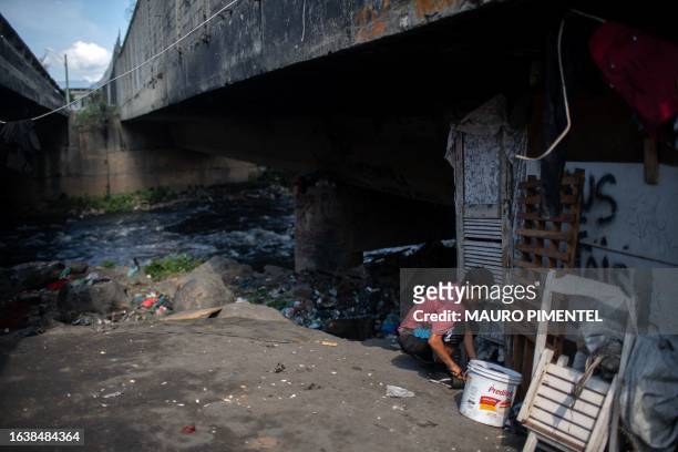 Homeless woman is seen in front of her wooden shack inside a homeless encampment in the suburbs of Rio de Janeiro, Brazil on July 31, 2023. Thirteen...