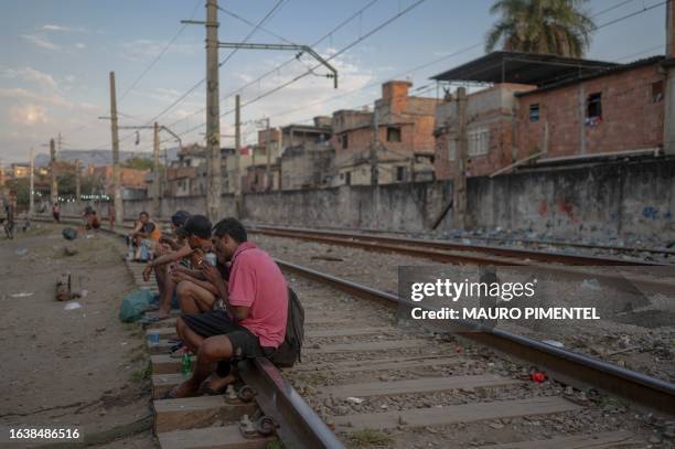 Homeless man smokes crack while sitting on a train line at the so called "Cracolandia" , a place where drug users addicted to crack gather, at the...