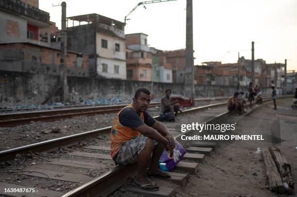 Homeless man sits on a train line at the so called "Cracolandia" , a place where drug users addicted to crack gather, at the Jacarezinho favela in...