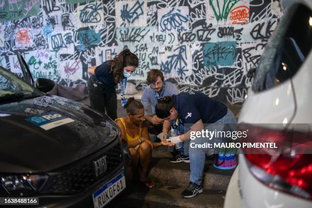 Physician Yasmine Nascimento and medical students provide medical treatment to a homeless woman with her hand injured inside a homeless encampment...