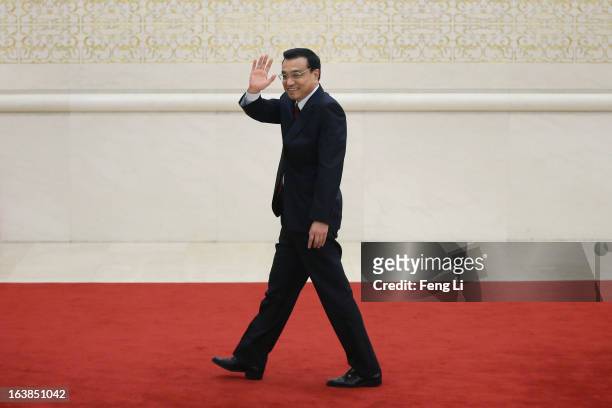 China's newly elected Premier Li Keqiang waves as he leaves a news conference after the closing session of the National People's Congress at the...
