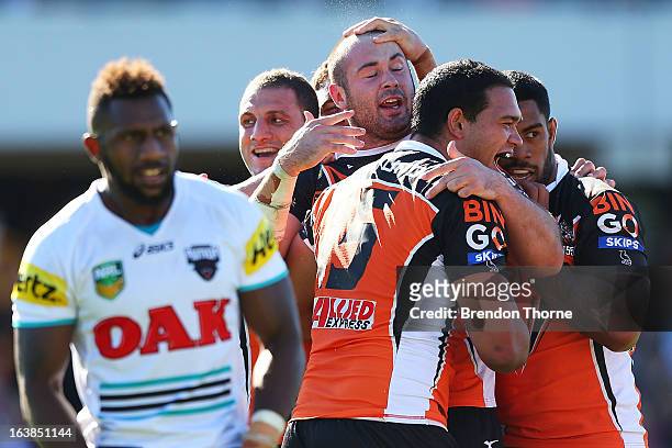 Aaron Woods of the Tigers celebrates with team mates after scoring during the round two NRL match between the Wests Tigers and the Penrith Panthers...