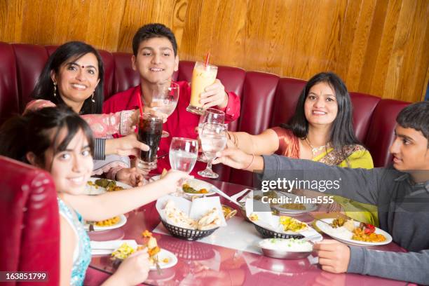 indian family celebrating something at the restaurant - restaurant kids stock pictures, royalty-free photos & images