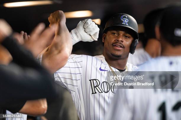 Elehuris Montero of the Colorado Rockies celebrates with teammates in the dugout after hitting a two-run home run in the third inning against the...