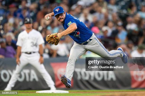 Davis Schneider of the Toronto Blue Jays throws to first base after fielding a soft ground ball against the Colorado Rockies in the third inning at...