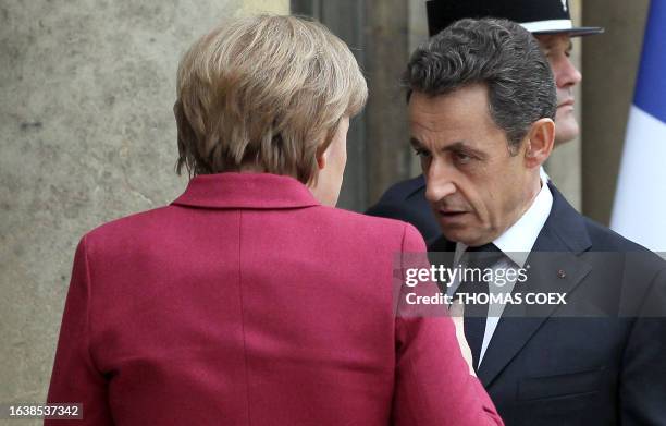 German Chancellor Angela Merkel listens to France's President Nicolas Sarkozy as she arrives on March 19, 2011 at the Elysee Palace in Paris, for a...