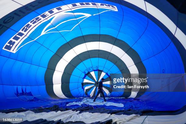 Pilot checks the inside of the envelope as a mass balloon launch takes place during the Yorkshire Balloon Fiesta on August 25, 2023 at Castle Howard...
