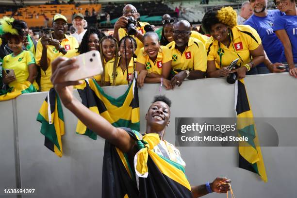 Shericka Jackson of Team Jamaica takes selfies with fans after winning gold in the Women's 200m Final during day seven of the World Athletics...