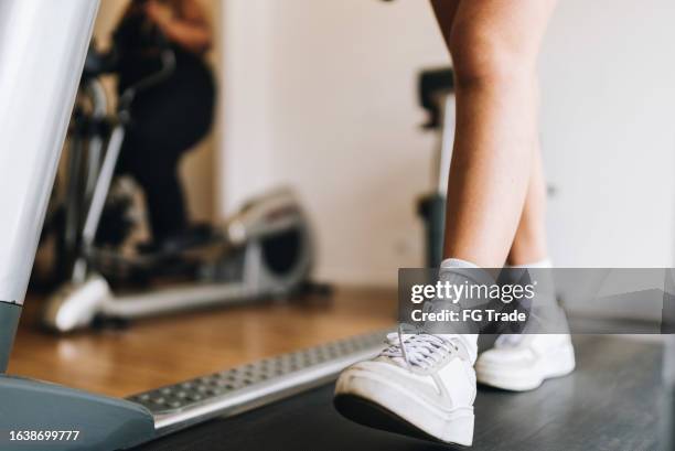 woman's legs walking on a treadmill at the gym - woman studio stock pictures, royalty-free photos & images