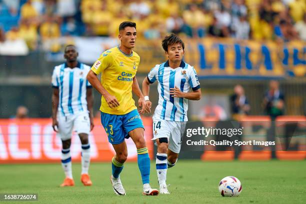 Sergi Cardona of UD Las Palmas competes for the ball with Takefusa Kubo of Real Sociedad during the LaLiga EA Sports match between UD Las Palmas and...